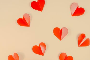 Red-Paper-Hearts-on-Beige-Background